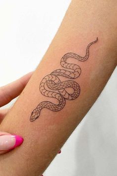 a woman's arm with a snake tattoo on it