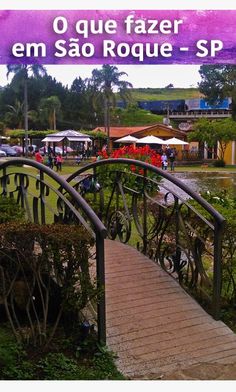 a wooden bridge over a lush green park filled with lots of plants and flowers on top of it