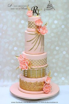 a pink and gold wedding cake with flowers on top