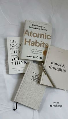 three books sitting on top of a bed next to each other