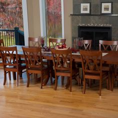 a dining room table and chairs in front of a fireplace