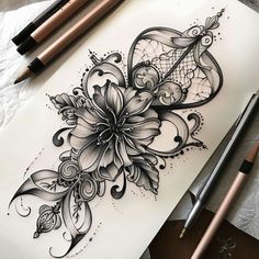 a drawing of flowers on paper next to some pencils