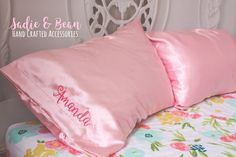 two pink pillows sitting on top of a bed