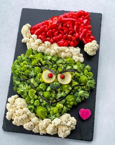 a piece of art made to look like broccoli and cauliflower with eyes