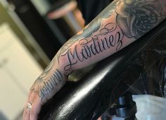 a man with a tattoo on his arm holding onto a chair and the words grandma written in cursive font