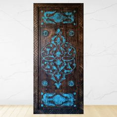 an ornate wooden door with blue paint on it