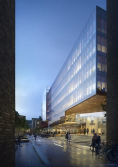 people walking and biking on the sidewalk in front of a large glass building at dusk