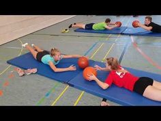 children playing with basketballs in an indoor gym