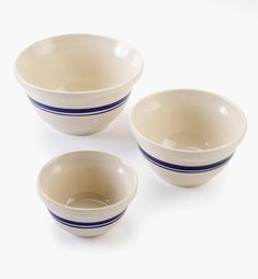 three white bowls with blue stripes on them