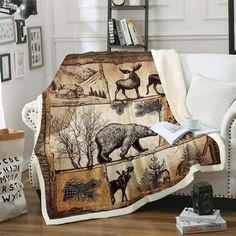 a living room with a white couch covered in a blanket that has animals and trees on it