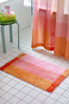 a bathroom with pink and orange rugs on the floor