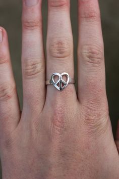 *DO NOT PURCHASE WITHOUT READING DESCRIPTION & BEING 100% CERTAIN OF SIZING, WE DO NOT OFFER REFUNDS* Sterling silver(tested) heart peace sign ring PRE-OWNED - NOT HANDMADE BY US Size(approx): 6.75 Weight(approx): 2.12g Length(approx): 0.5" Marked 925  Please contact us here or via social media if you have any questions about this item   Due to the nature of this product being a Pre-Owned item it is not perfect, consider this before purchase. Heart Peace Sign, Peace Sign Ring, Peace Ring, Not Perfect, Sterling Silver Heart, Peace Sign, Signet Ring, Rings Statement, Statement Rings