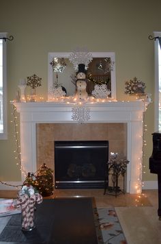 a living room filled with furniture and a fire place covered in christmas lights next to a fireplace