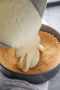 someone is pouring batter into a pan filled with food