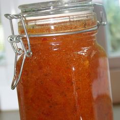 a glass jar filled with red liquid sitting on top of a counter