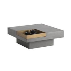 a square concrete table with two candles in it