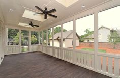 an empty screened porch with ceiling fans and wood flooring in front of the windows