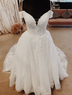 a white wedding dress on display in a room