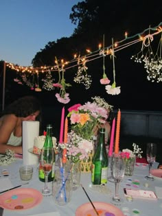 the table is set with flowers, candles and wine glasses for an outdoor dinner party