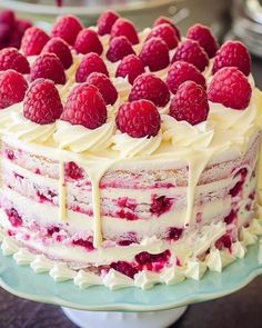 a cake with white frosting and raspberries on top