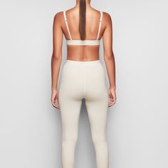 These cotton leggings hug the body yet allow your skin to breathe with cool and comfy natural fibers. The classic, rustic design elevates your lounge look. | SKIMS Legging | White | Cotton Rib Snug Fit Elastane Leggings For Pilates, Fitted Gym Leggings With Ribbed Waistband, Fitted Athleisure Leggings With Ribbed Waistband, Fitted Yoga Leggings With Ribbed Waistband, Full Length Seamless Athleisure Tights, Fitted Seamless Activewear, Seamless Full-length Athleisure Tights, Sporty Snug Fit Seamless Leggings, Everyday Seamless Fitted Activewear