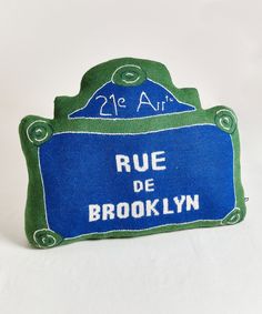 a blue and green sign that says rue de brooklyn on it's front side