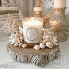 a white candle sitting on top of a wooden table next to shells and sea urns