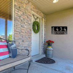 a front porch with a bench and wreath on it