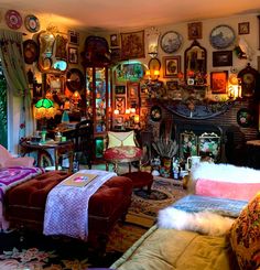 a living room filled with lots of furniture and pictures on the wall above it's fireplace