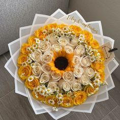 a bouquet of yellow and white flowers on top of a table