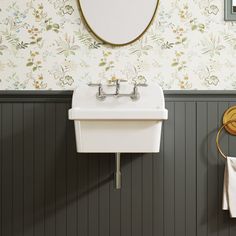 a white sink sitting under a mirror next to a wall mounted faucet in a bathroom