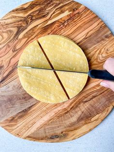 a person cutting up some tortilla on a wooden board