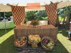 a table set up with fruit and vegetables under a tent at an outdoor gathering event