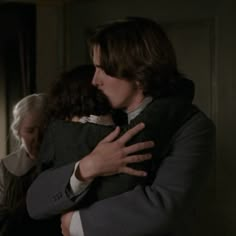 two people hugging each other in a room