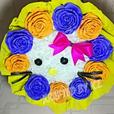 a cake decorated with flowers and a cat's face