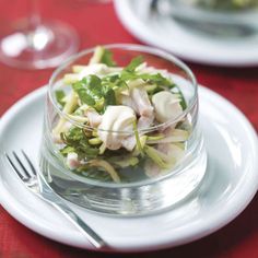 a glass bowl filled with salad on top of a white plate