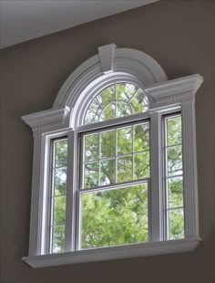 an open window with white trim on the outside and trees in the backround