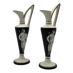 two black and white vases sitting side by side with one holding a woman's head