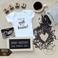 a baby announcement is displayed with coffee, photos and magnets to spell out the word'time to spill the beans '