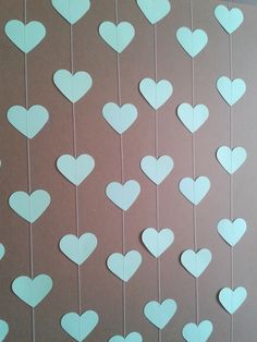 paper hearts hanging from strings on a wall