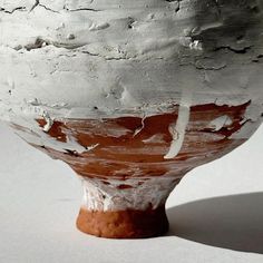 a white and brown vase sitting on top of a table