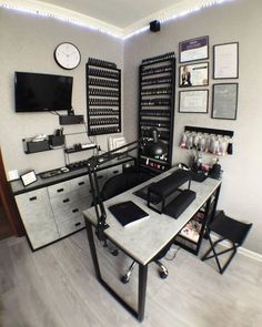 a computer desk with lots of wine bottles on the wall behind it and a clock mounted to the wall