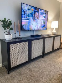 a flat screen tv sitting on top of a wooden entertainment center in a living room