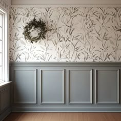 an empty room with wallpaper and a wreath hanging on the wall next to it