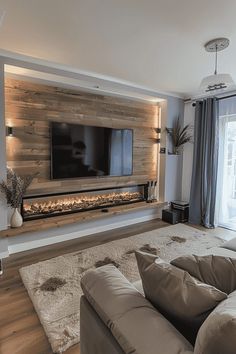 a living room with couches and a flat screen tv mounted on the wall above it