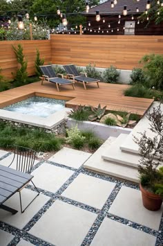 an outdoor hot tub in the middle of a patio with chairs and lights strung over it