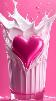 a heart shaped milk splashing out of a glass with water on the bottom and pink background