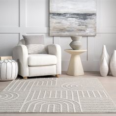 a living room area with white furniture and art on the wall, along with two large vases