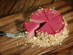 a piece of cake sitting on top of a wooden cutting board next to a knife