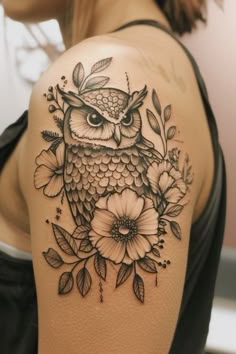 an owl and flowers tattoo on the shoulder